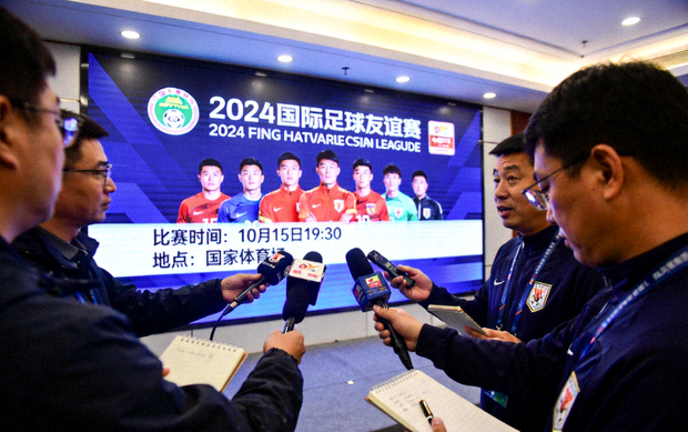体育新闻发布现场记者与赛事信息屏幕画面
